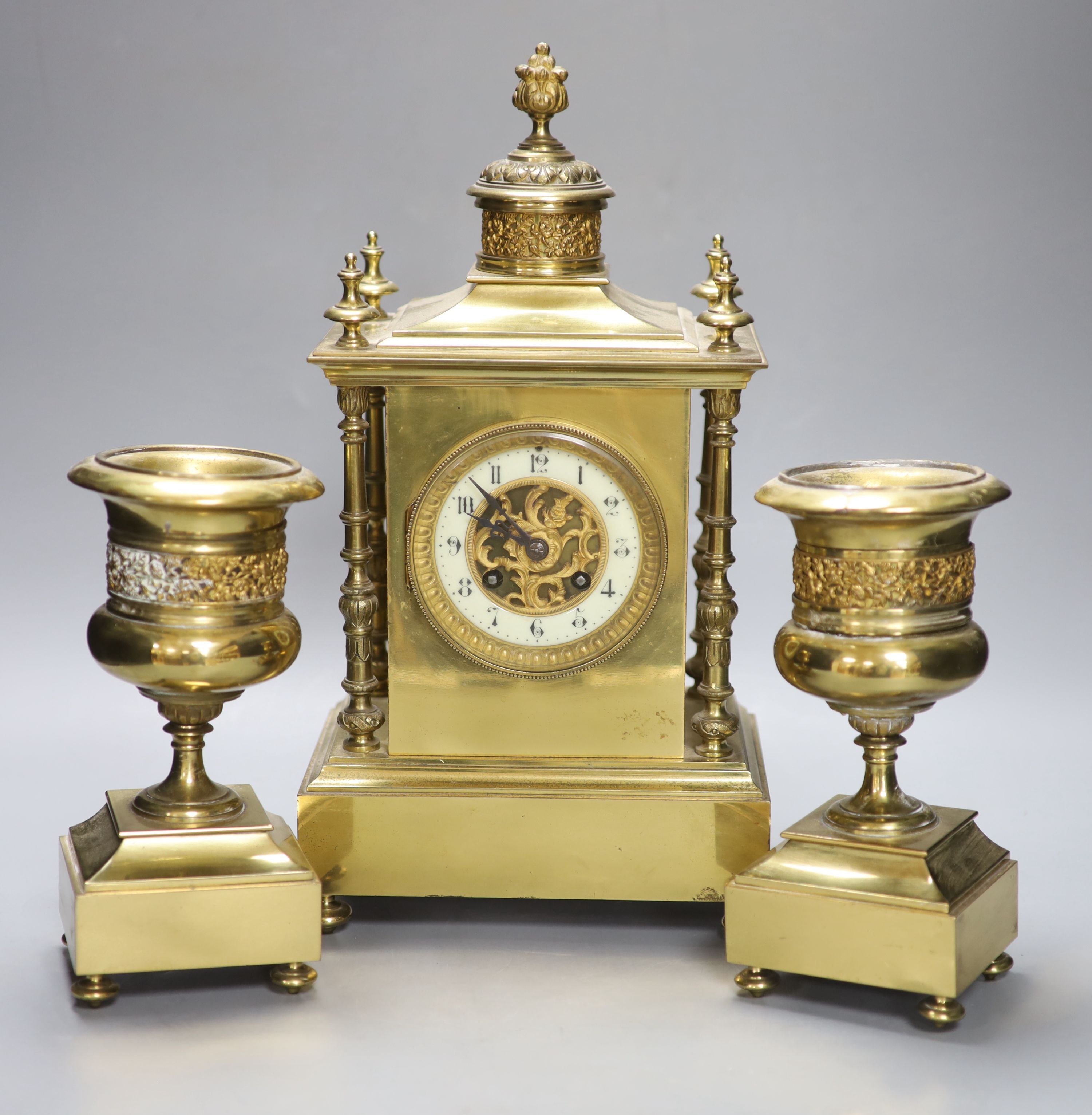 A late 19th century gilt brass three piece clock garniture, the clock with an eight day striking movement, height 39cm